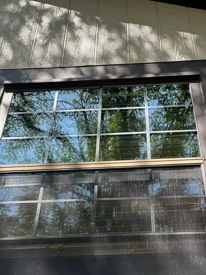 Window with clear upper glass and a dirty grey screen still covering the lower half